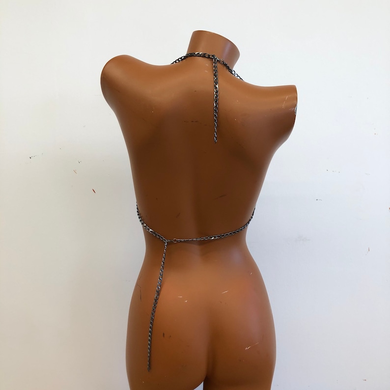 K&ouml;nnte beinhalten: Ein silbernes Ketten-Halter-Top mit einer langen Kette, die am R&uuml;cken herunterh&auml;ngt.
