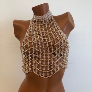 May include: A gold chain body jewelry piece with clear beads. The chain is layered and has a halter style neckline.