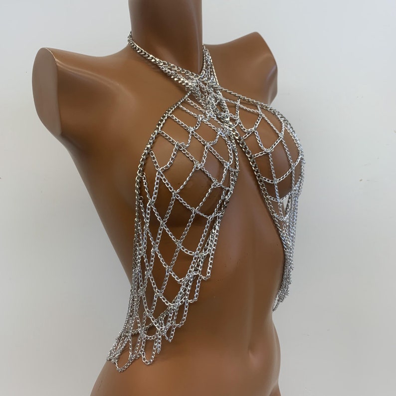 May include: Silver chainmail top with a criss-cross design and dangling chains.