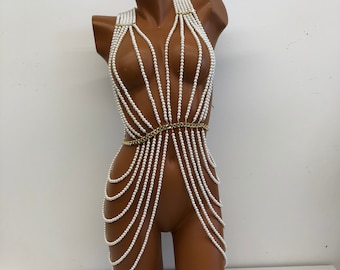 May include: A white pearl body chain with a gold chain accent at the waist.