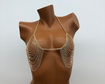 May include: A gold chain body jewellery piece with a layered design. The chain is made of small, linked circles.