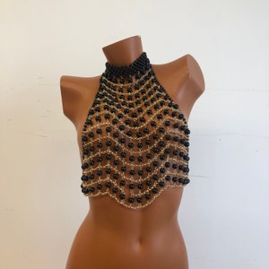 May include: A black and gold beaded halter top with a scalloped bottom.