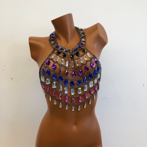 K&ouml;nnte beinhalten: Ein mehrfarbiger Kristall-Kettenhemd-Oberteil mit einem Halterneck. Das Oberteil ist mit rosa, blauen und violetten Kristallen besetzt.