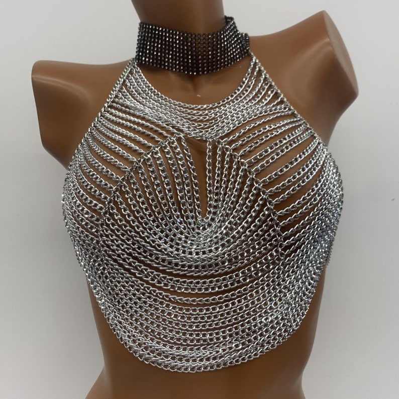 May include: Silver chainmail halter top with a black rhinestone choker.