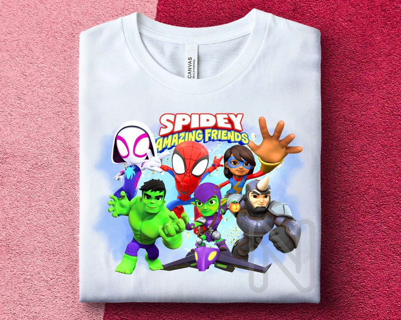 May include: White t-shirt with a colorful graphic of Spider-Man and his friends. The graphic includes Spider-Man, Green Goblin, Ghost Spider, Rhino, and a female superhero. The text "SPIDEY AMAZING FRIENDS" is printed above the graphic.
