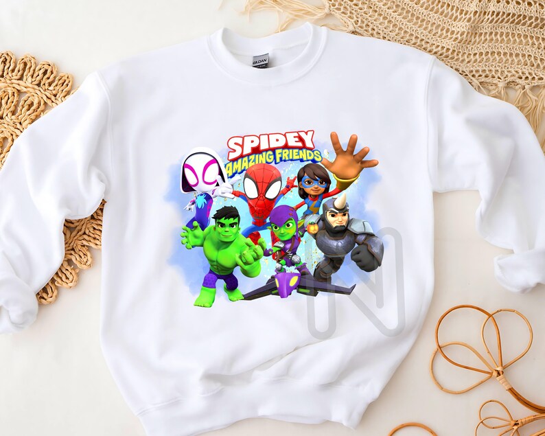 May include: White sweatshirt with a colorful graphic print of Spider-Man and his friends. The text "SPIDEY AMAZING FRIENDS" is printed above the characters.