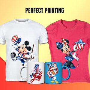 Op de afbeelding: Twee T-shirts met patriottische ontwerpen met Mickey Mouse en Minnie Mouse. Het witte T-shirt heeft Mickey Mouse met een rood-wit-blauwe hoed en een stok. Het roze T-shirt heeft Minnie Mouse met een rood-wit-blauwe jurk en een stervormige ballon. Er zijn ook twee mokken met patriottische ontwerpen. Een mok heeft een rood-wit-blauw ontwerp met de tekst "4th of July". De andere mok heeft een blauw ontwerp met Donald Duck met een rood-wit-blauwe hoed en een vlag.
