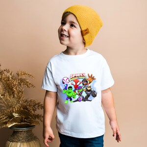 May include: A white t-shirt with a colorful graphic of Spider-Man and his friends. The graphic says "Spidey Amazing Friends".
