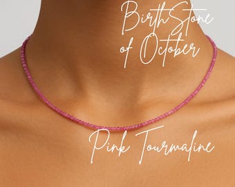 Puede incluir: Un delicado collar de turmalina rosa. El collar está compuesto por pequeñas cuentas rosas redondas. El texto de la imagen dice "Birth Stone of October" y "Pink Tourmaline".