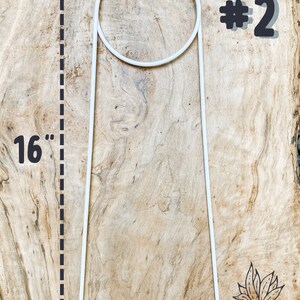 May include: White metal plant stand with a 16-inch height and a circular top. The stand is labeled #2.