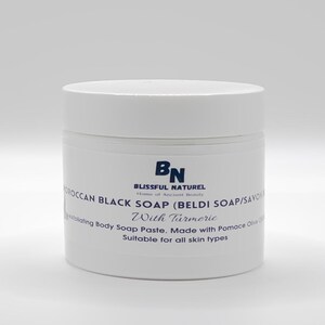 May include: A white jar of Moroccan black soap with turmeric. The label reads "BLISSFUL NATUREL" and "Moroccan Black Soap (Beldi Soap/Savon) With Turmeric". The jar is a body soap paste made with pomace olive oil, suitable for all skin types.