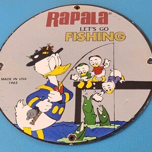 Cartel publicitario vintage de señuelos de pesca Rapala: Plato de surtidor de gasolina de porcelana con el Pato Donald