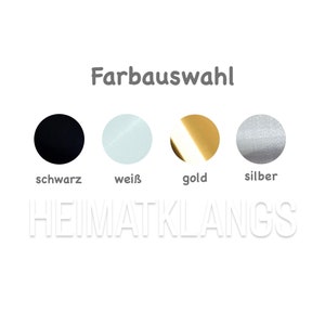 May include: Color options for a product, shown as four circles: black, white, gold, and silver. The text "Farbauswahl" is above the circles, and the text "HEIMATKLANGS" is below the circles.
