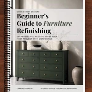 May include: A spiral-bound book titled Beginner's Guide to Furniture Refinishing by Charene Robinson. The cover features a dark green dresser with gold knobs, two vases, and a small bowl, with the text Everything You Need To Start Your First Project With Confidence.