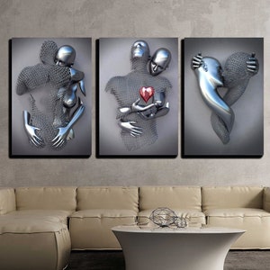 May include: A three-piece canvas wall art set featuring a silver-toned sculpture of a couple embracing. The sculpture is made of a wire mesh material and has a red heart in the center. The artwork is set against a gray background.