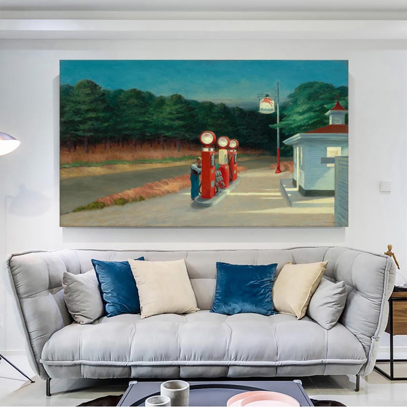 Op de afbeelding: Een schilderij van een tankstation 's nachts met drie rode benzinepompen en een wit gebouw. Het tankstation bevindt zich in een landelijke omgeving met bomen op de achtergrond. Het schilderij is in realistische stijl en heeft een gedempt kleurenpalet.