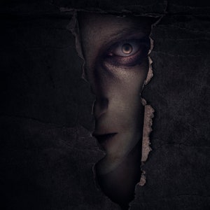 Puede incluir: Primer plano de un rostro que asoma a través de un agujero rasgado en una superficie oscura y texturizada. El ojo de la persona es visible, con una mirada oscura y sombría.
