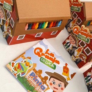 May include: A red and brown cardboard box with a cutout for crayons. The box has a sign that says "La Granja de Luca" and a picture of a rooster. The box is next to a colouring book with the same title and a picture of a boy and a parrot.