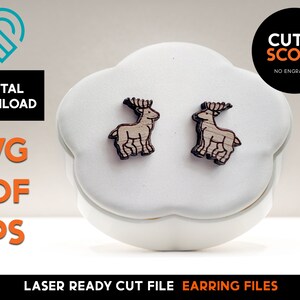 May include: A pair of laser cut wooden earrings featuring a deer design. The earrings are in a small white box with the text "CUT & SCORE NO ENGRAVING" on a black label. The text "DIGITAL DOWNLOAD SVG PDF EPS LASER READY CUT FILE EARRING FILES" is also visible.