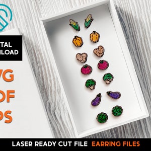 Könnte beinhalten: Eine weiße Box mit einer Auswahl an bunten, lasergeschnittenen Ohrring-Designs. Die Designs umfassen Mais, Paprika, Kartoffeln, Tomaten, Brokkoli, Auberginen und Kohl. Der Text "LASER READY CUT FILE EARRING FILES" ist auf der Unterseite der Box aufgedruckt.