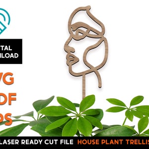 May include: A laser cut wooden house plant trellis in the shape of a stylized face. The trellis is designed to be used as a decorative support for climbing plants.