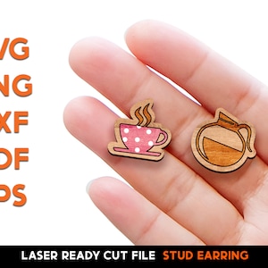 May include: Two laser cut wooden stud earrings. One earring is a pink coffee cup with white polka dots and steam coming from the top. The other earring is a brown coffee pot with a black outline.