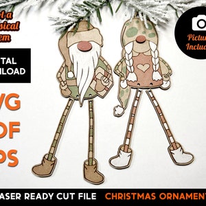 Könnte beinhalten: Ein digitaler Download von zwei Laser-geschnittenen Weihnachtsbaumschmuck-Designs mit Gnomen. Die Gnome tragen Hüte und haben lange Beine. Die Designs sind bereit, auf einem Laserschneider geschnitten zu werden.