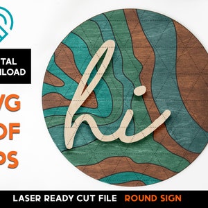 May include: A round wooden sign with a layered, abstract design in shades of brown and teal. The word "hi" is cut out of the wood and layered on top of the design.