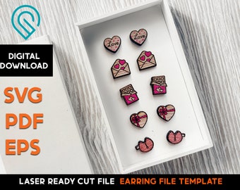 May include: A white box with a variety of laser cut wooden earrings. The earrings are shaped like hearts, envelopes, and chocolate bars. The earrings are decorated with pink hearts and the word "Love".