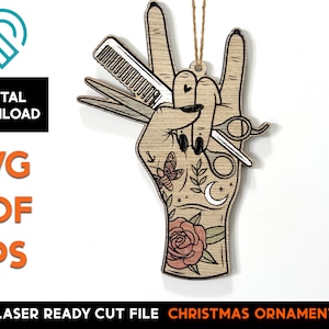 May include: A laser cut wooden Christmas ornament shaped like a hand giving the rock and roll sign. The hand is tattooed with a rose, a crescent moon, a butterfly, and a small anchor. The hand is holding a pair of scissors and a comb.