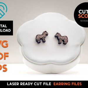 May include: A pair of laser cut wooden zebra earrings. The earrings are on a white display stand. The image includes the text "CUT & SCORE NO ENGRAVING".