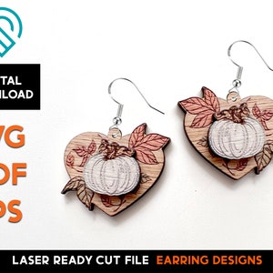 May include: A pair of laser cut wooden earrings featuring a heart shape with a pumpkin and leaves design. The earrings are ready to be assembled and are perfect for fall.