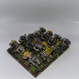 Peut inclure: Un groupe de 18 figurines miniatures peintes de cr&eacute;atures ressemblant &agrave; des rats avec des &eacute;p&eacute;es et des boucliers, debout sur une base brune avec de l'herbe verte. Les figurines sont peintes dans des tons de gris, de brun et de jaune.