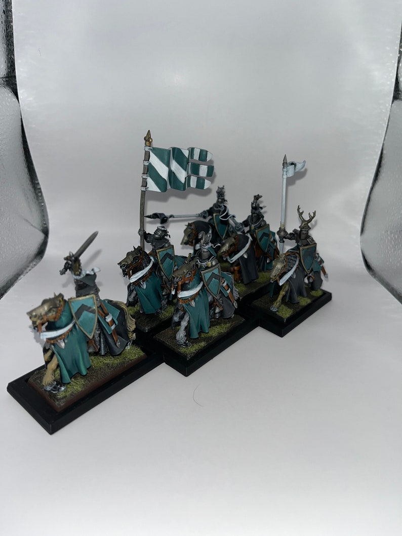 Peut inclure: Un groupe de six chevaliers miniatures &agrave; cheval, peints en vert et blanc, avec des &eacute;p&eacute;es et des boucliers. Les chevaliers sont dispos&eacute;s en ligne, avec un drapeau &agrave; l'avant.