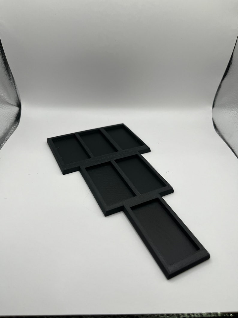 Peut inclure: Plateau en plastique noir avec plusieurs compartiments, con&ccedil;u pour organiser de petits objets.