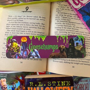 May include: A purple Goosebumps book with a green, slimy monster on the cover. The book is open to page 54 and the text reads "Kids - it's okay!" Dr. Brewer called. He bent down quickly, picked up the baseball cap, and replaced it on his head."