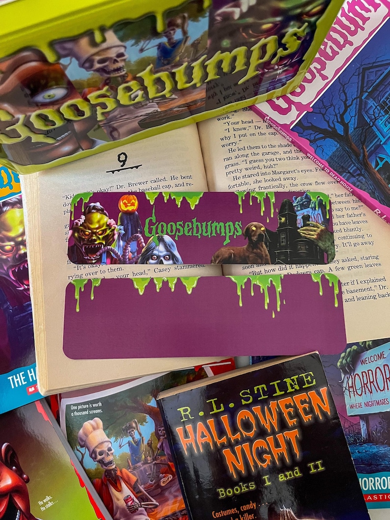 May include: A stack of Goosebumps books with a purple and green bookmark. The bookmark has a green slime dripping from the top and the words "Goosebumps" in white letters. The book titles are "Welcome to Dead House" and "Halloween Night, Books I and II".