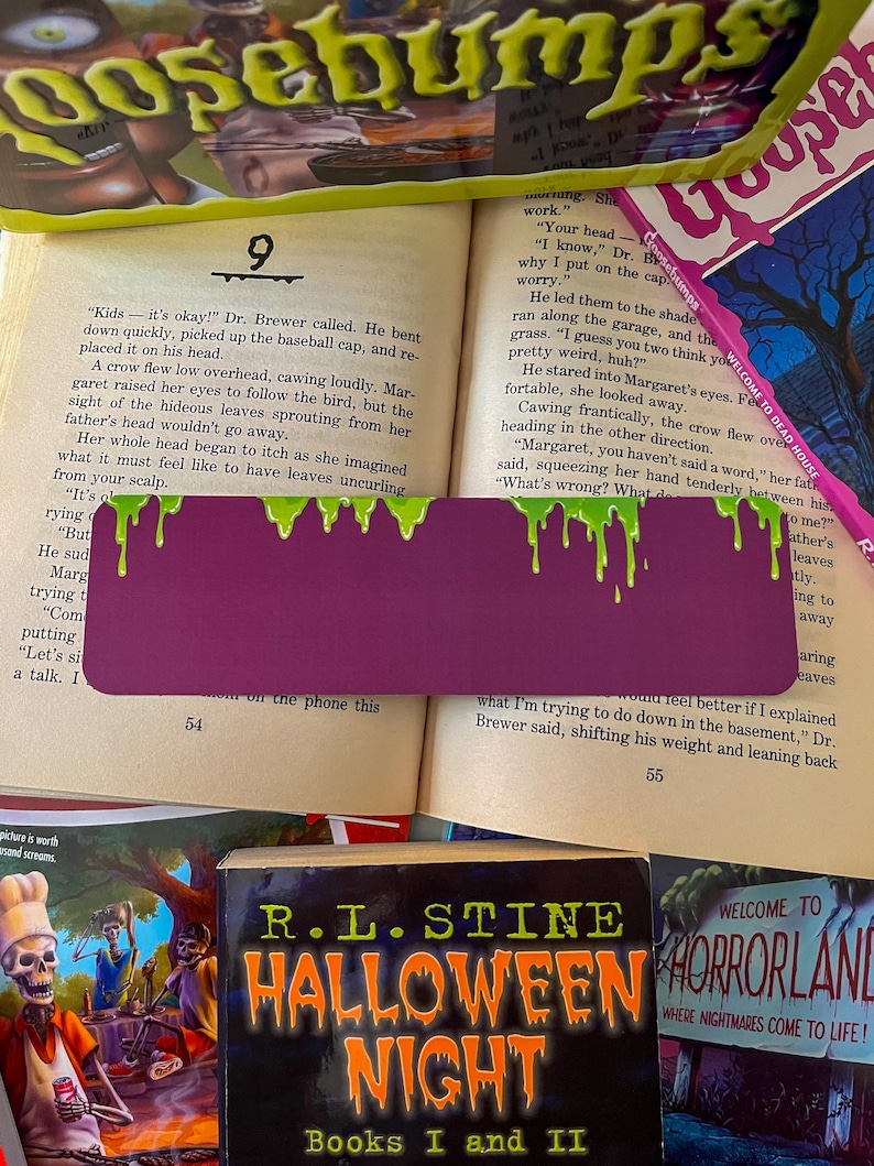 May include: A close-up of a purple bookmark with green dripping paint on it. The bookmark is placed on a page of a book titled "Goosebumps" with the text "Kids - it's okay!" and "What's wrong?" visible. The book is open to page 54.