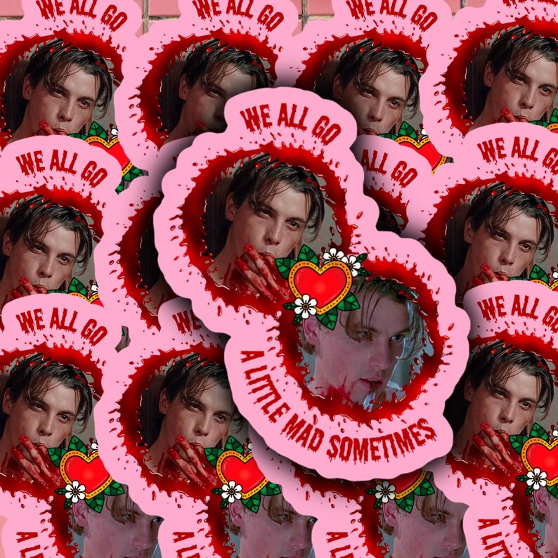 May include: Pink and red sticker with a bloody hand and a heart with flowers. The sticker has the text "We all go a little mad sometimes".