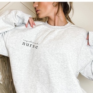 May include: A grey sweatshirt with the text "registered nurse" printed on the front.