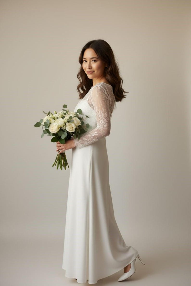 Bride wearing a white lace top with long sheer sleeves, styled as a wedding dress topper lace bolero shrug and floral lace blouse for wedding.