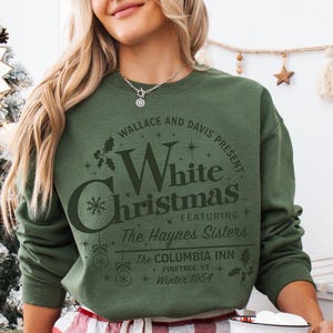 May include: Green sweatshirt with a white graphic print that reads "Wallace and Davis Present White Christmas Featuring The Haynes Sisters The Columbia Inn Pinetree, VT Winter 1954".