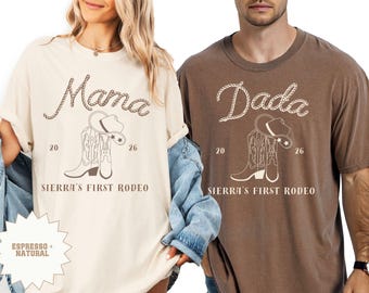 May include: Two t-shirts, one cream and one brown, with rodeo-themed graphics. The cream shirt says "Mama" and the brown shirt says "Dada." Both shirts feature a cowboy hat and boots design, with "Sierra's First Rodeo" printed below.