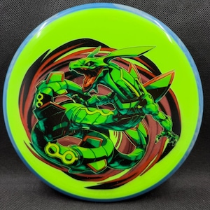 May include: A neon green disc golf disc with a blue rim. The disc features a detailed illustration of a green dragon with red and black accents. The dragon is in a dynamic pose, suggesting movement.