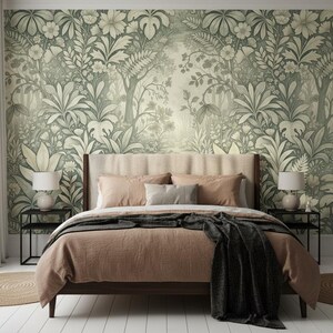 May include: A bedroom featuring a bed with a tan duvet and a dark gray throw blanket, flanked by two black metal nightstands with white lamps. The wall behind the bed is covered in wallpaper with a repeating sage green and cream botanical pattern.