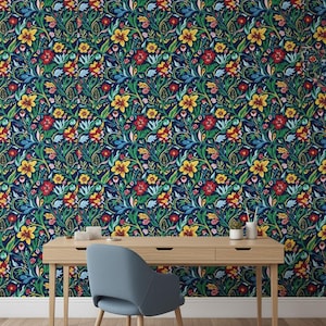 May include: A light blue upholstered chair with a curved back and four wooden legs positioned in front of a wall covered in dark blue wallpaper featuring a dense, repeating pattern of yellow, red, and light blue flowers with green leaves.