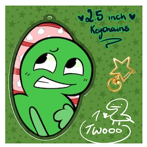 May include: A green cartoon character keychain with a star-shaped clasp. The keychain is 2.5 inches in size and features the text "Keychains" and "Twooo". The background is green with star patterns.