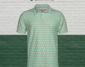 May include: A light green short-sleeved polo shirt with a white background and a repeating pattern of cartoon faces wearing hats. The shirt has a collar and a button placket. The text "MOODY ON THE GREEN" is printed on the shirt. The text "WHERE FUN MEETS FAIRWAY FASHION" is printed below the main text.