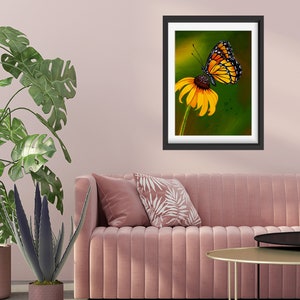 Gouache painting titled 'Flutterby' features a yellow monarch butterfly on a cone flower against a green background. Adds natural elegance to any space.