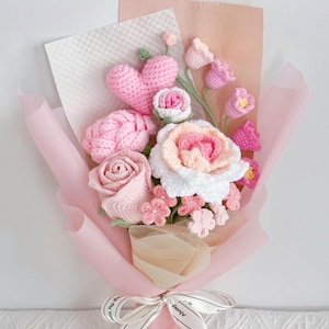 May include: A pink crocheted bouquet of flowers with a heart in the centre. The bouquet is wrapped in pink tissue paper and tied with a white ribbon that says "Always & Forever".